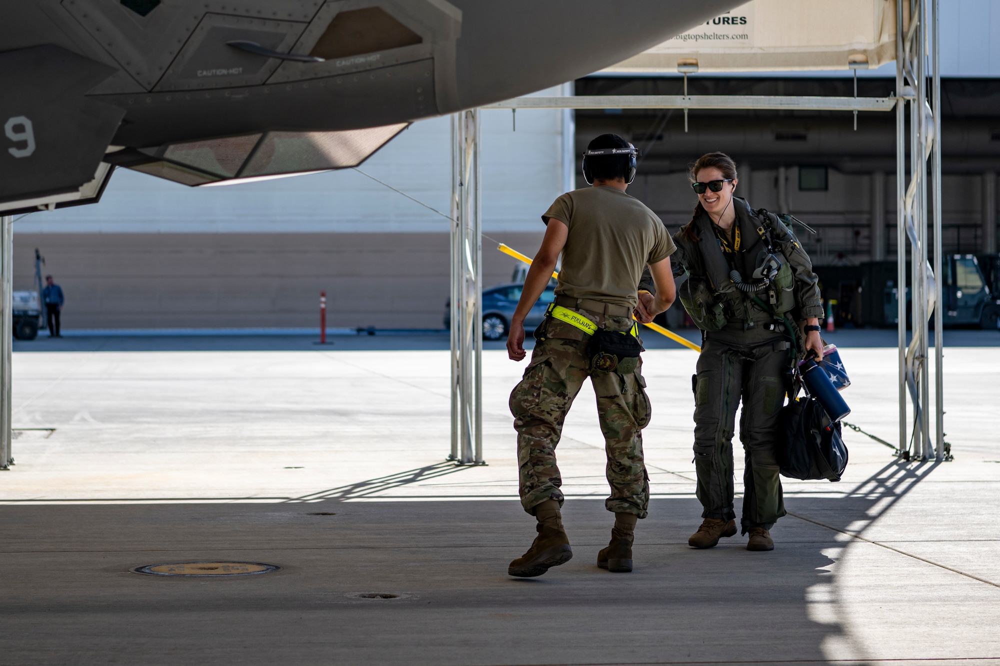 A photo of an Air Force maintainer greeting a pilot in front of an F-35.