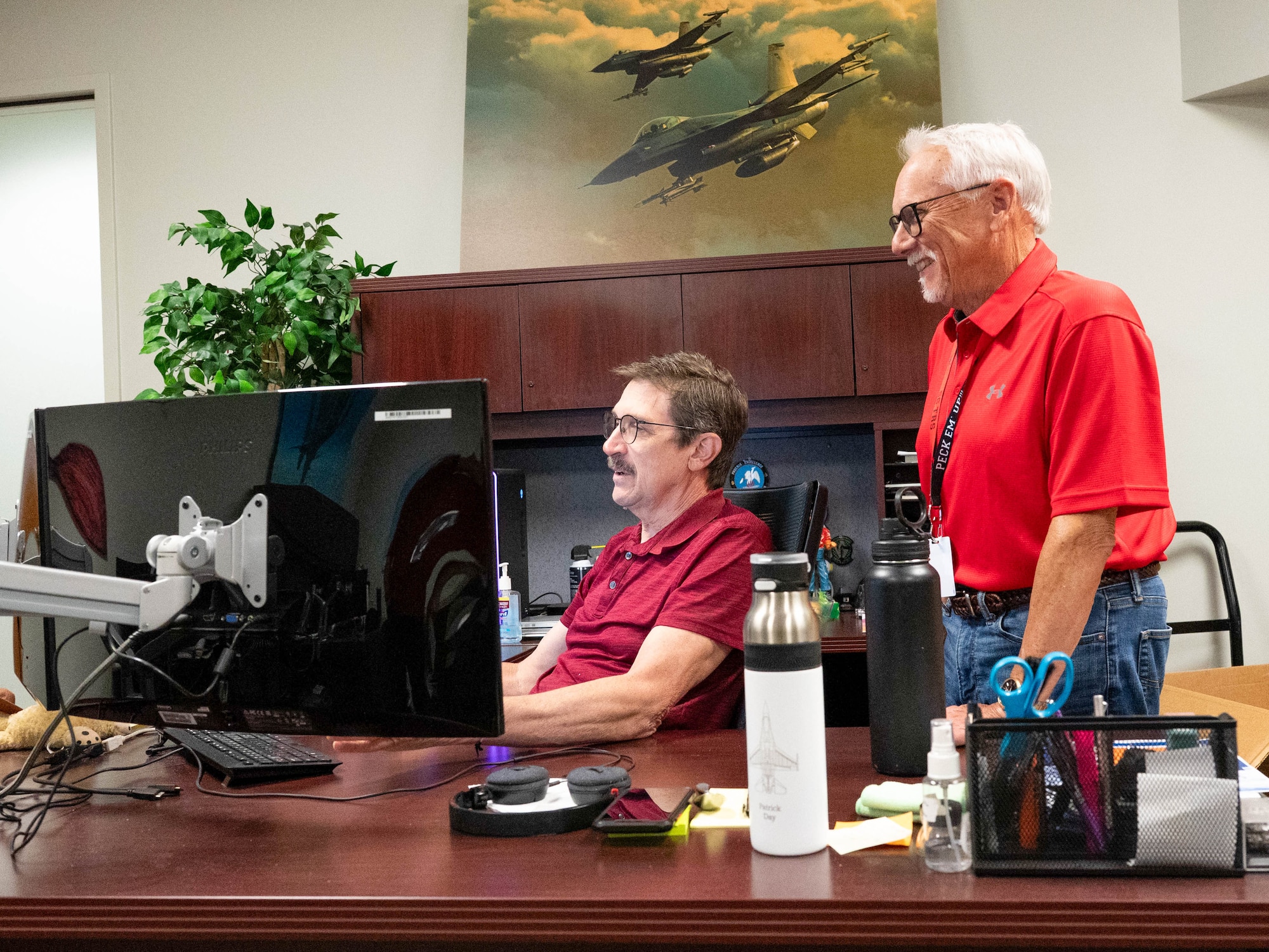 Patrick Day (left), 56th Training Squadron instructional design manager, works at his desk as Gregory Daniels (right), 56th Training Squadron instructional systems specialist, assists, Aug. 8, 2025, at Luke Air Force Base, Arizona.