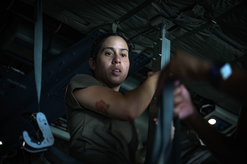U.S. Air Force Capt. Christabel Munoz, 18th Aeromedical Evacuation Squadron flight nurse, helps configure a litter setup on a C-130J Super Hercules assigned to the Kentucky Air National Guard 165th Airlift Squadron, during a mass casualty training event at Yokota Air Base, Japan, July 22, 2025. The 18 AES worked alongside the 3rd Marine Division and the 165 AS to treat and load 57 role players simulated as patients