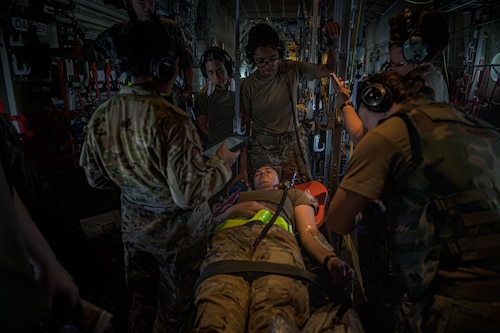 U.S. Air Force Airmen from the 18th Aeromedical Evacuation Squadron treat a patient during a simulated in-flight response before a mass casualty training event in the Indo-Pacific region July 22, 2025. Airmen executed two other high-intensity scenarios, including a mid-flight mass casualty response and a prolonged trauma care scenario aboard the aircraft.