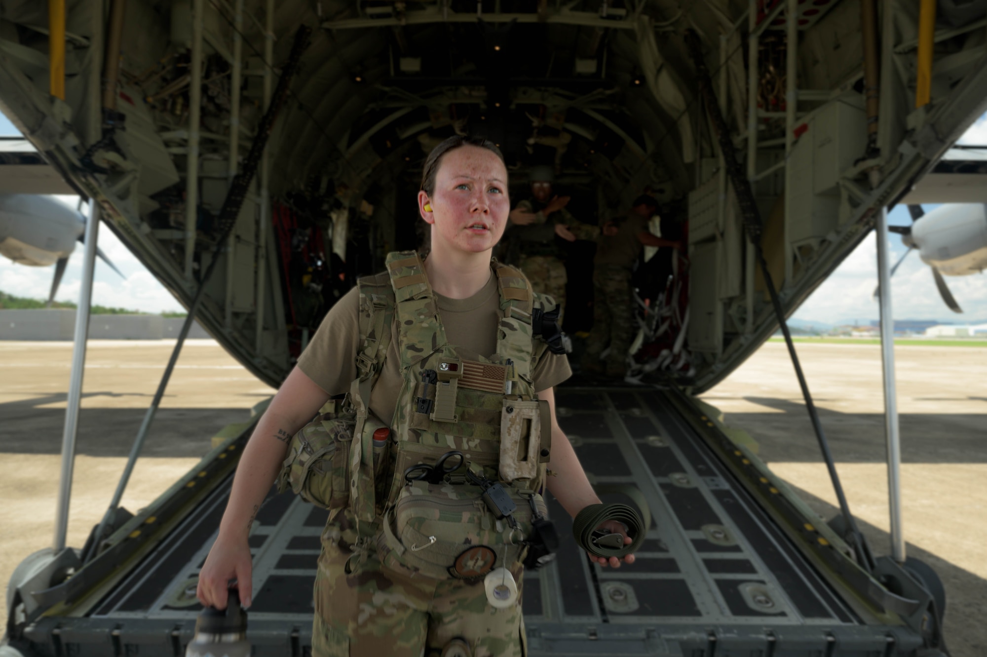 U.S. Air Force Senior Airman Custie Bulloch, 18th Aeromedical Evacuation Squadron aeromedical evacuation technician, steps out of a C-130J Super Hercules assigned to the Kentucky Air National Guard 165th Airlift Squadron, during a mass casualty training event in the Indo-Pacific region, July 22, 2025. The training brought together Airmen, Marines, and Air National Guard members to strengthen joint interoperability in patient care and aeromedical evacuation.