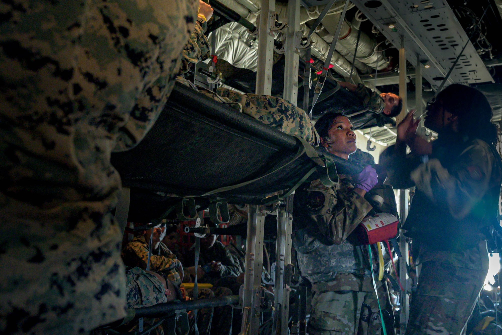 U.S. Air Force Airmen from the 18th Aeromedical Evacuation Squadron load a patient aboard a C-130J Super Hercules assigned to the Kentucky Air National Guard 165th Airlift Squadron, during a mass casualty training event in the Indo-Pacific region, July 22, 2025. The 18th AES worked alongside the 3rd Marine Division and the 165th AS to treat and load 57 simulated patients.