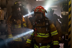 Firefighters walk through a building