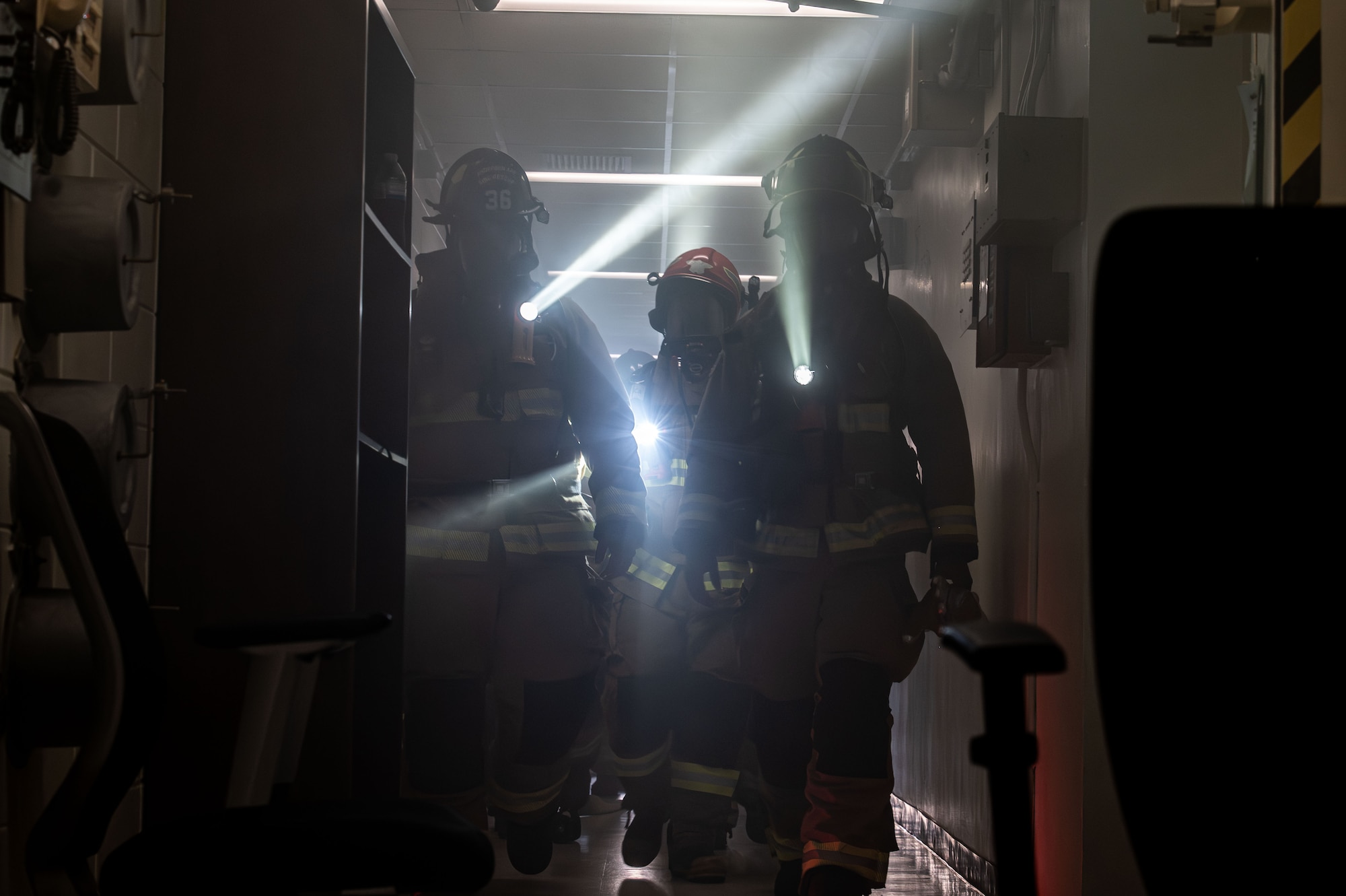 A group of firefighters walk through a building