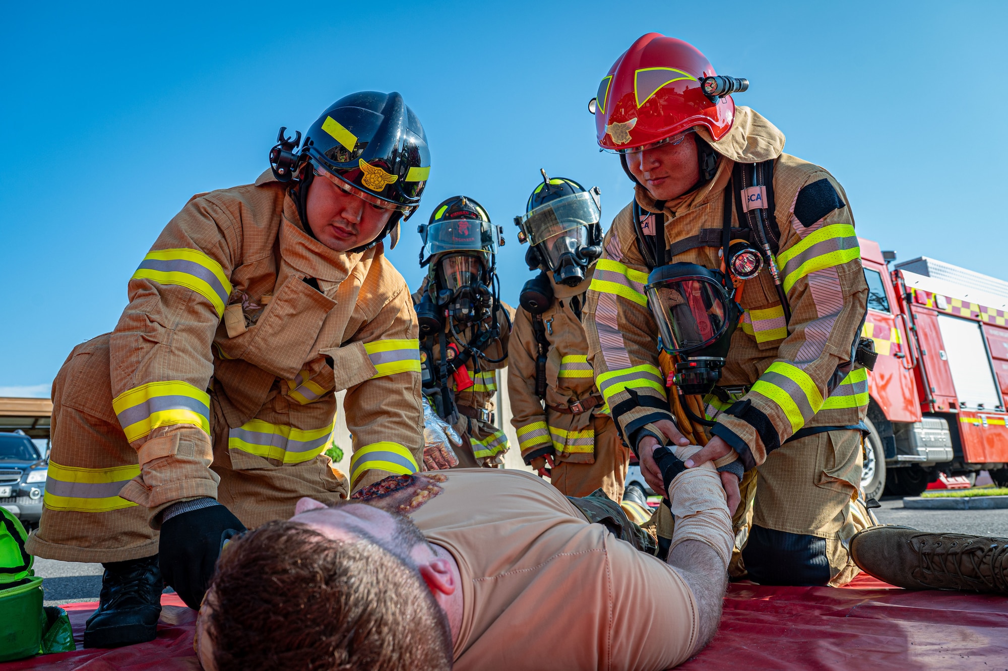 4 Firefighters assess a mans condition after a fire