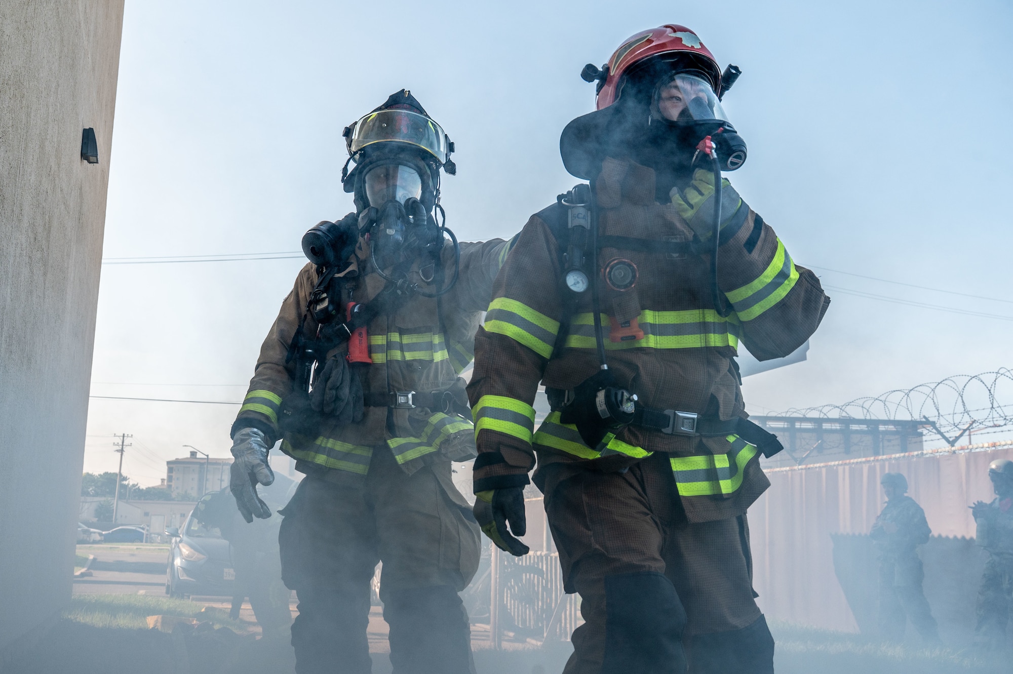 Two firefighters enter a building