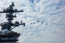 Aircrafts, attached to Carrier Air Wing 9 (CVW9) fly over the flight deck of the Nimitz-class aircraft carrier USS Abraham Lincoln (CVN 72) during Northern Edge 2025 (NE25).