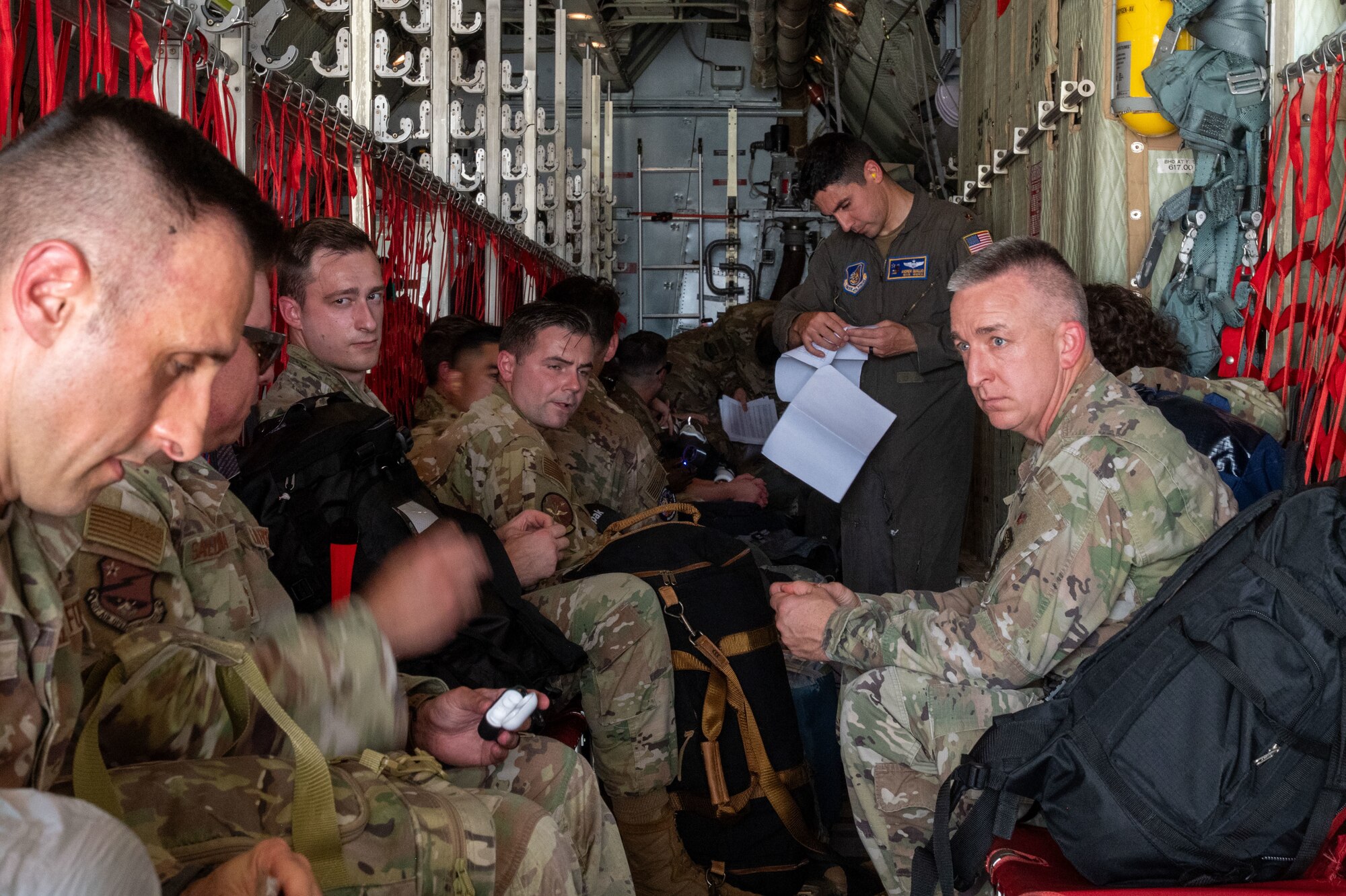 People walk on the flightline with planes parked.