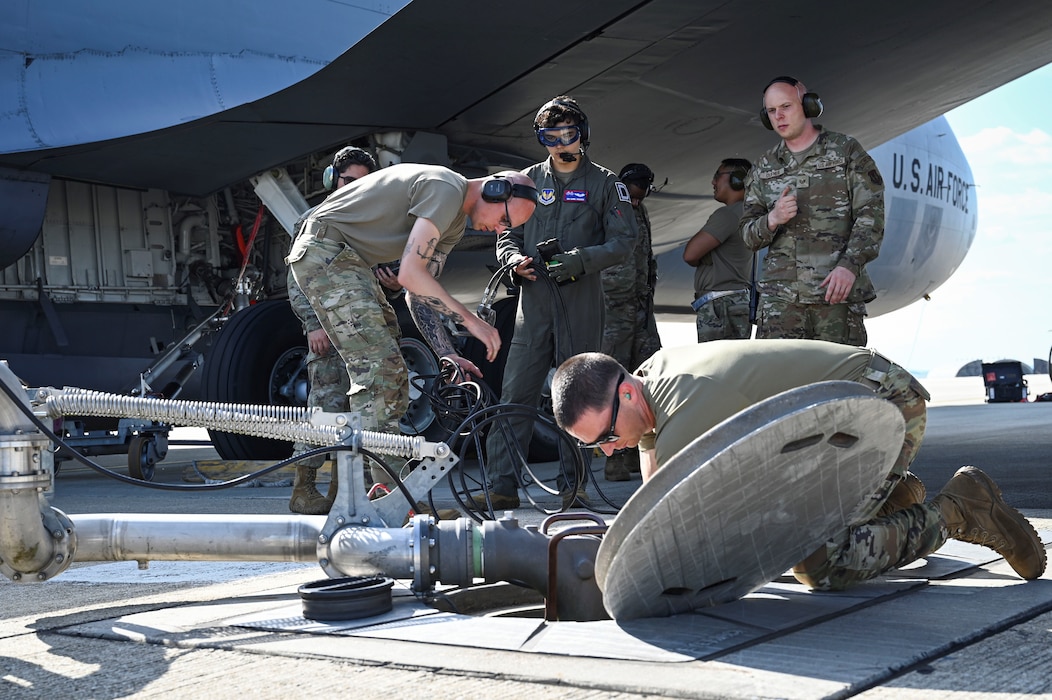 U.S. Air Force Airmen assigned to the 52nd Logistics Readiness Squadron, attaches a moosehead connection to a hydrant pit and sensing lines during hot refueling training on a KC-135 Stratotanker aerial refueling aircraft.