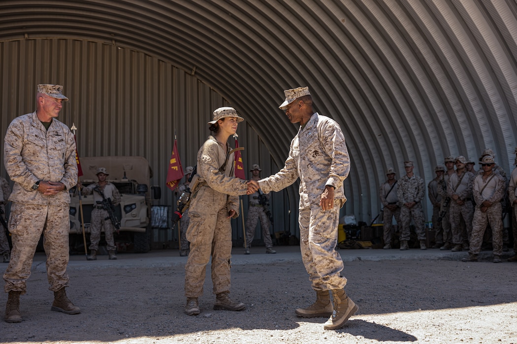 U.S. Marine Corps Lt. Gen. Calvert L. Worth, the commanding general of II Marine Expeditionary Force, shakes hands with Lance Cpl. Aubrey Wells, a small arms repairer with 2d Battalion, 8th Marines, 2d Marine Regiment, 2d Marine Division, during a recognition ceremony as part of Service Level Training Exercise 4-25, at Marine Corps Air-Ground Combat Center, Twentynine Palms, California, Aug. 17, 2025. SLTE 4-25 is designed to be a challenging, realistic training environment that produces combat-ready forces capable of operating as an integrated Marine Air Ground Task Force across all domains of military operations. (U.S. Marine Corps photo by Lance Cpl. Judith Ann Lazaro)