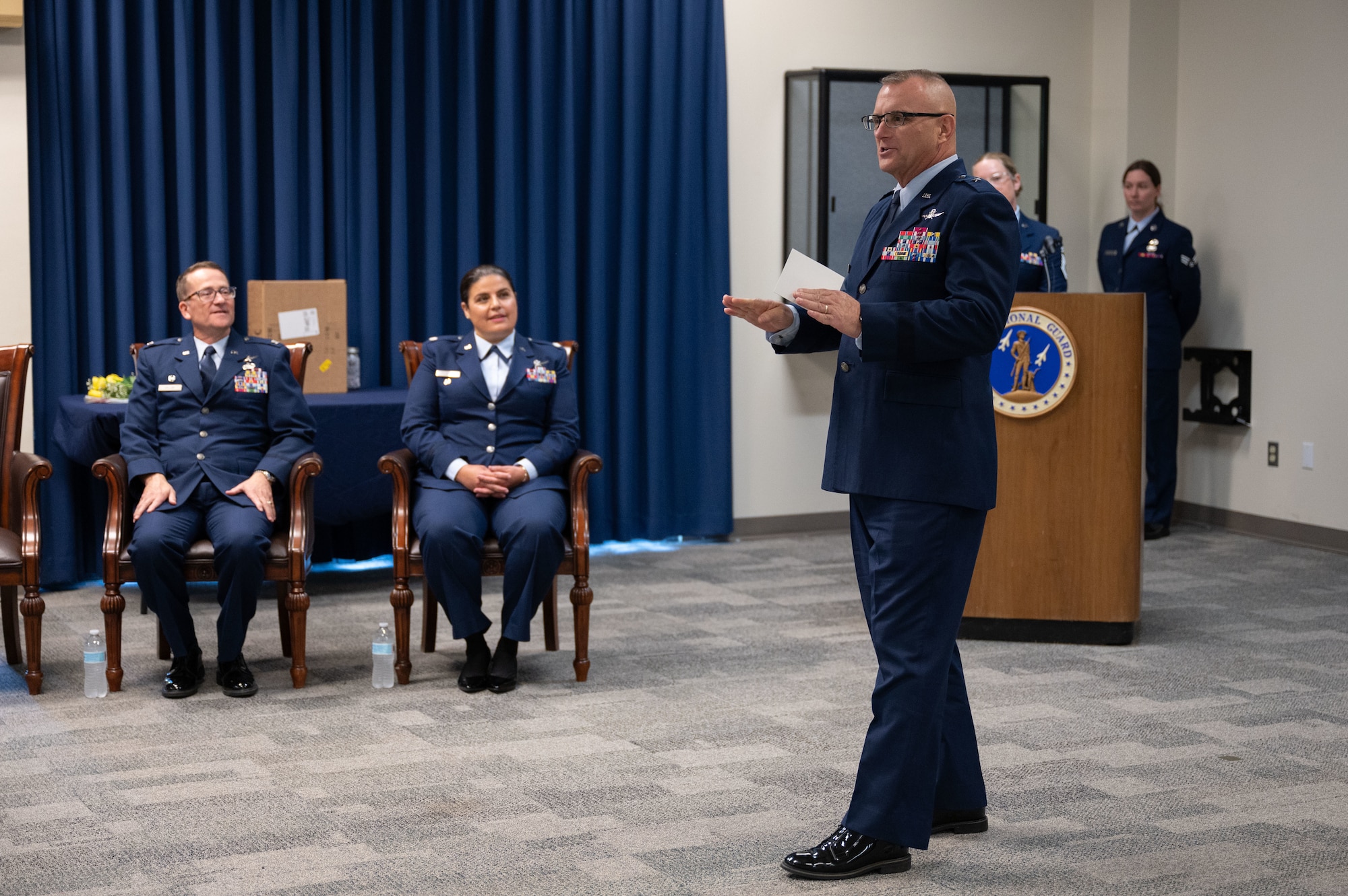 Airman stands in front of an audience.