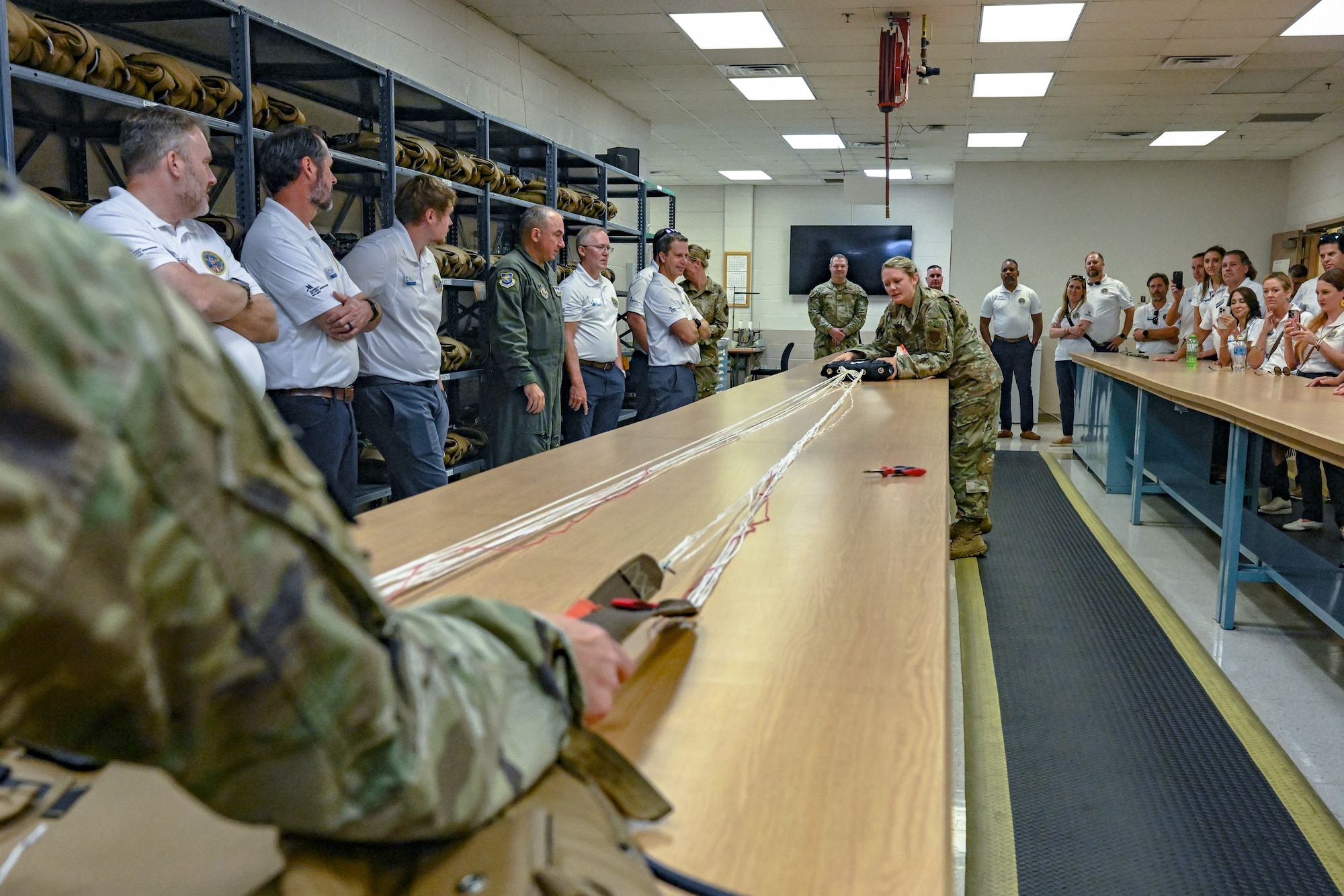 Tech. Sgt. Nicole Sabo, an aircrew flight equipment instructor with the 910th Operations Support Squadron, performs a parachute inspection and packing demonstration for civic leaders from Dobbins Air Reserve Base, Georgia, on Aug. 14, 2025, at Youngstown Air Reserve Station, Ohio.