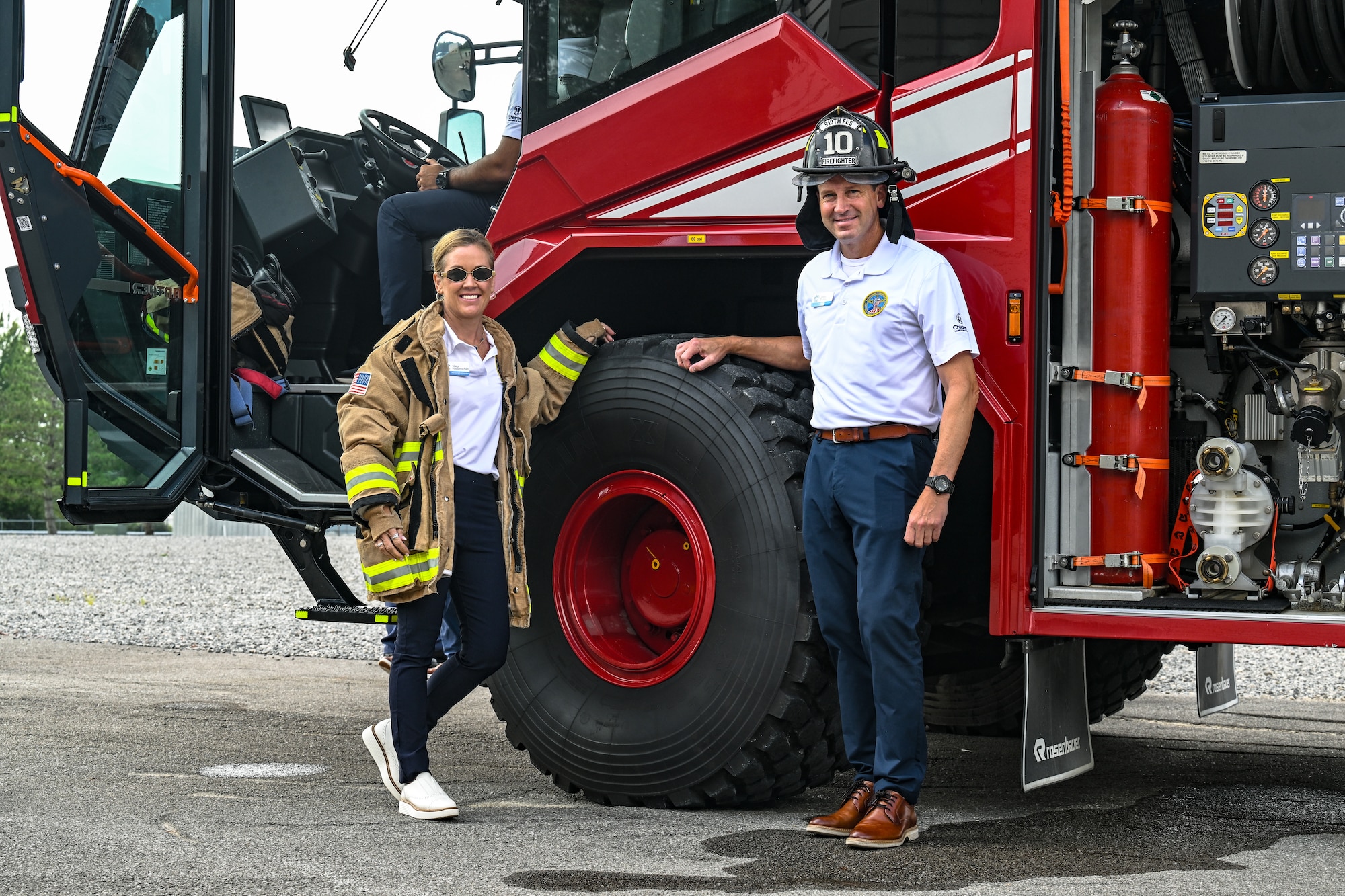 Civic leaders from Dobbins Air Reserve Base, Georgia, pose for a photo wearing firefighter gear on Aug. 14, 2025, at Youngstown Air Reserve Station, Ohio.