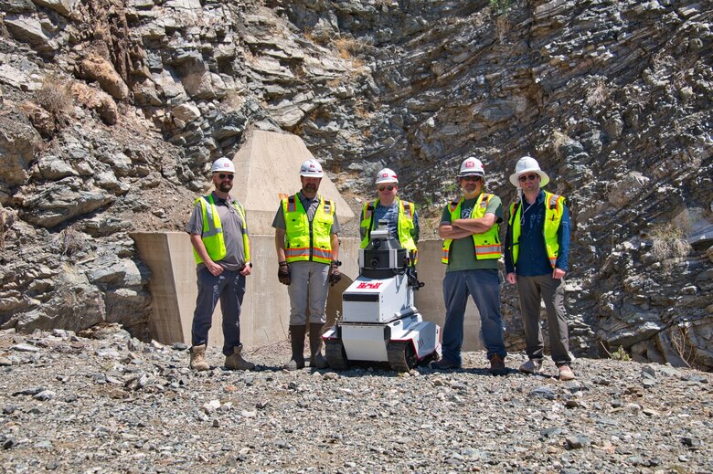 Mini Dambot team stands for picture with the robot