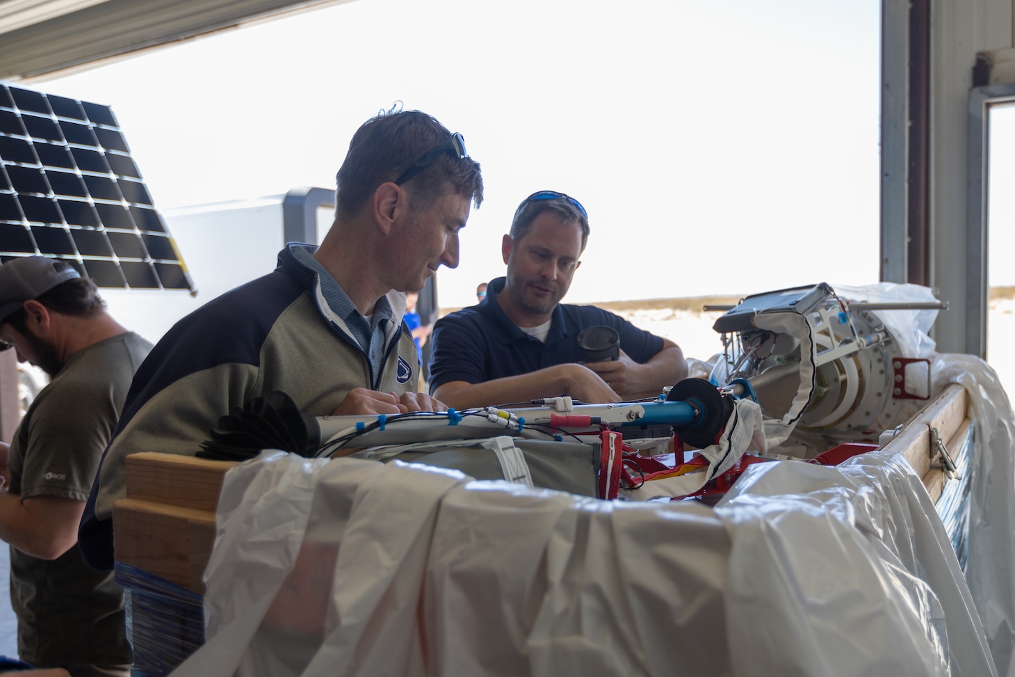 Richard Stroman, Head, Alternative Energy Section, U.S. Naval Research Laboratory (NRL), left, and Mark Ketcham, Aerostar, review a High Altitude Balloon (HAB) prior to unpacking during a technical demonstration held at Outlying Landing Field Seagle in Twentynine Palms, Calif. May 19-21, 2025. The U.S. Naval Research Laboratory in conjunction with the Operational Energy Capability Improvement Fund with the Office of the Assistant Secretary of Defense for Energy, Installations, and Environment, and the Marine Corps Expeditionary Energy Office (E2O) conducted the demonstration aiming to develop a technology for Navy vessels to "see over the horizon" using a combination of stratospheric high-altitude balloons (HABs) and unmanned aircraft. (U.S. Marine Corps photo by Pfc. Jozef Mejewski/Released)