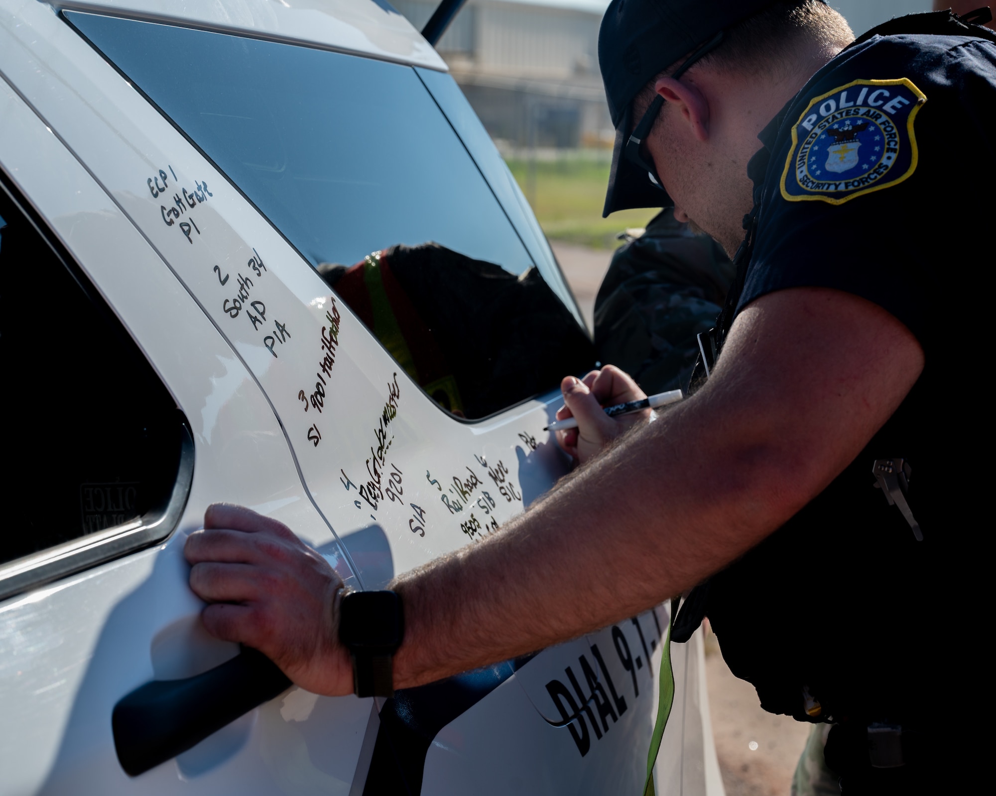 Police officer writes on car with dry erase marker