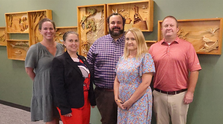 Picture of five people standing in front of a wall