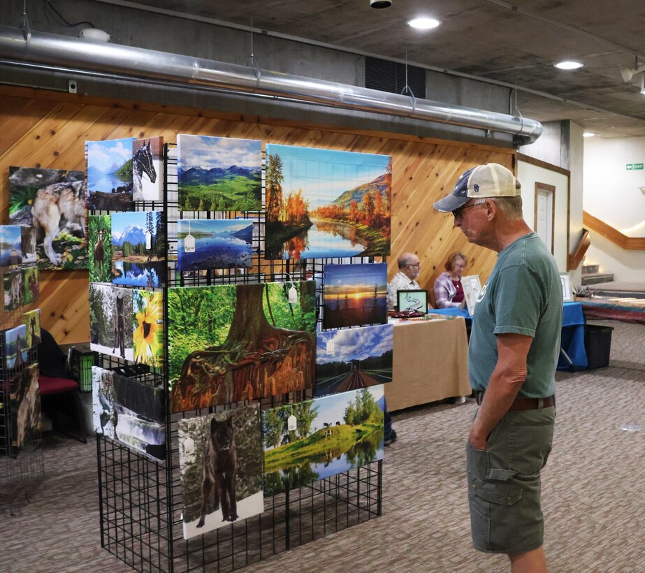 Attendees view artwork displayed in Libby Dam's Visitor Center, during the dam's Open House event, as part of the 50th commemoration, Aug. 23, 2025. The commemoration recognizes the achievements of former and current U.S. Army Corps of Engineers, Seattle District employees in building and maintaining the dam, and the partnerships that made it possible.