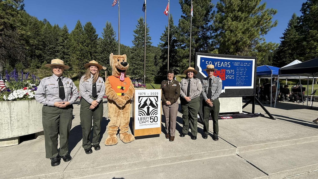U.S. Army Corps of Engineers, Seattle District Commander Col. Kathryn Sanborn with members of the district's natural resource specialist team and Bobber the Water Safety Dog, pose for a group photo during Libby Dam's 50th commemoration, Aug. 23, 2025, at Libby, Montana.