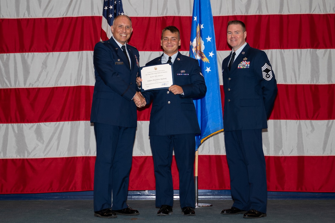U.S. Air Force Col. Michael Maginness, 2nd Bomb Wing commander, Airman 1st Class Tykhon Rudenok, 2nd Civil Engineer Squadron heating, ventilation and air conditioning journeyman, and Chief Master Sgt. Thomas Podgorski, 2nd Maintenance Group senior enlisted leader, pose for a photo during a Naturalization Ceremony at Barksdale Air Force Base, Louisiana, July 15, 2025. After moving to the U.S. from Ukraine in 2014, Rudenok battled homelessness, but later joined the Air Force in February 2023. (U.S. Air Force photo by Airman 1st Class Jaiyah Lewis)