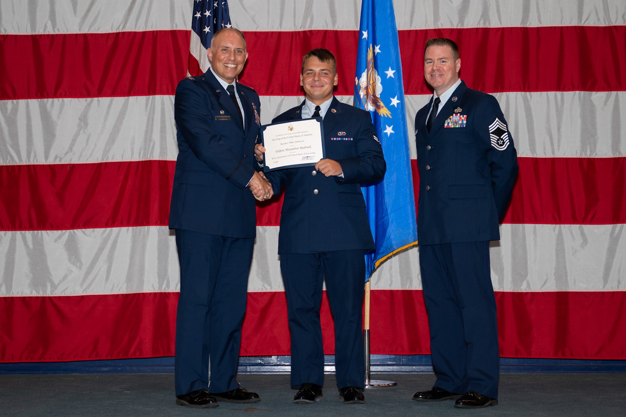 U.S. Air Force Col. Michael Maginness, 2nd Bomb Wing commander, Airman 1st Class Tykhon Rudenok, 2nd Civil Engineer Squadron heating, ventilation and air conditioning journeyman, and Chief Master Sgt. Thomas Podgorski, 2nd Maintenance Group senior enlisted leader, pose for a photo during a Naturalization Ceremony at Barksdale Air Force Base, Louisiana, July 15, 2025. After moving to the U.S. from Ukraine in 2014, Rudenok battled homelessness, but later joined the Air Force in February 2023. (U.S. Air Force photo by Airman 1st Class Jaiyah Lewis)