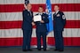 U.S. Air Force Col. Michael Maginness, 2nd Bomb Wing commander, Airman 1st Class Tykhon Rudenok, 2nd Civil Engineer Squadron heating, ventilation and air conditioning journeyman, and Chief Master Sgt. Thomas Podgorski, 2nd Maintenance Group senior enlisted leader, pose for a photo during a Naturalization Ceremony at Barksdale Air Force Base, Louisiana, July 15, 2025. After moving to the U.S. from Ukraine in 2014, Rudenok battled homelessness, but later joined the Air Force in February 2023. (U.S. Air Force photo by Airman 1st Class Jaiyah Lewis)