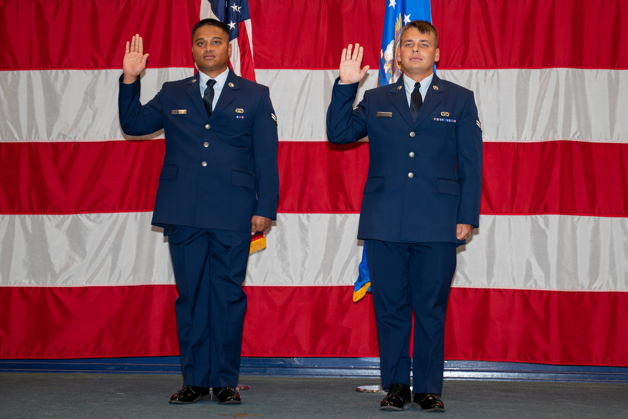 U.S. Air Force Airman 1st Class Atson Nameta, 2nd Logistics Readiness Squadron individual protection equipment apprentice, and Airman 1st Class Tykhon Rudenok, 2nd Civil Engineer Squadron heating, ventilation and air conditioning apprentice, take the Oath of Allegiance during a Naturalization Ceremony at Barksdale Air Force Base, Louisiana, July 15, 2025. A Naturalization Ceremony is a formal event where non-citizen U.S. service members officially become U.S. citizens through the naturalization process due to their military service. (U.S. Air Force photo by Airman 1st Class Jaiyah Lewis)