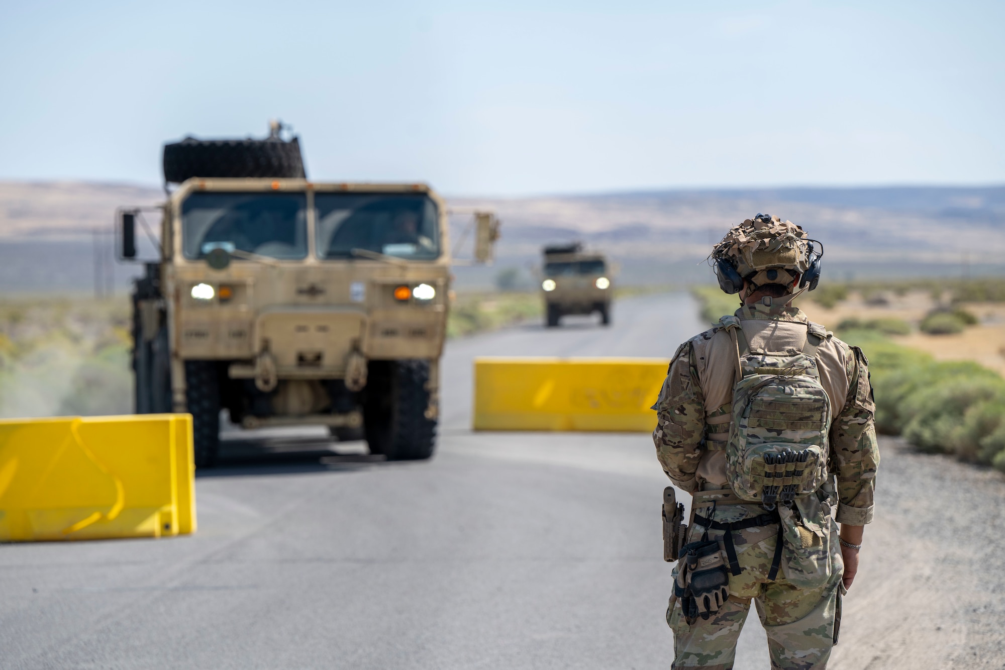 Man Stands in front of vehicles.