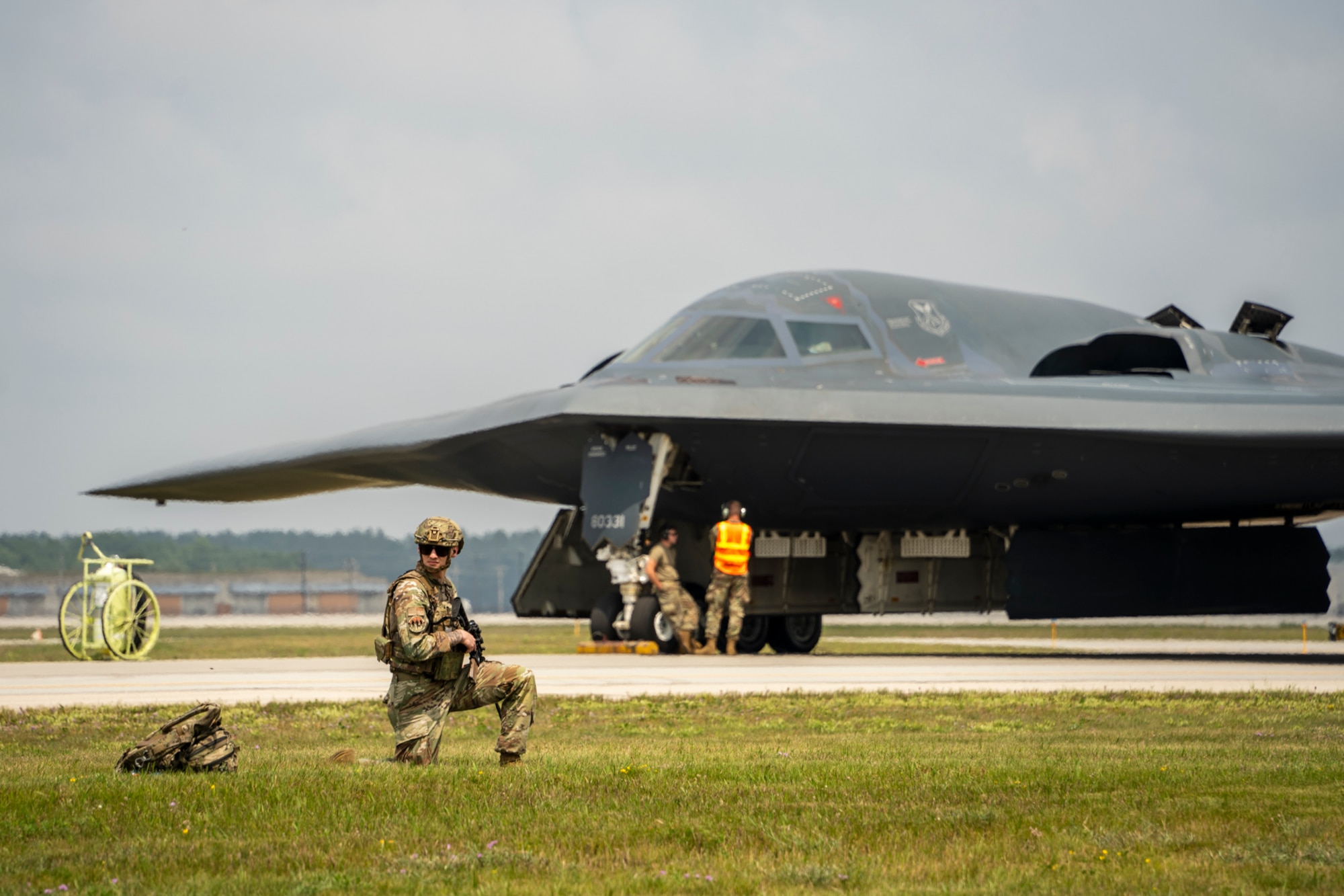 U.S. Air Force Senior Airman Daunte Dassinger, a security response team member assigned to the 509th Security Forces Squadron, establishes a Protection Level 2 perimeter for B-2 Spirit stealth bomber aircrew changeover, Aug. 5, 2025, in Oscoda, Michigan. The flight crew changeover was conducted during Exercise Northern Strike, a National Guard Bureau sponsored training event designed to build readiness with joint and partner forces in all domains of warfare. (U.S. Air National Guard photo by Staff Sgt. Whitney Erhart)