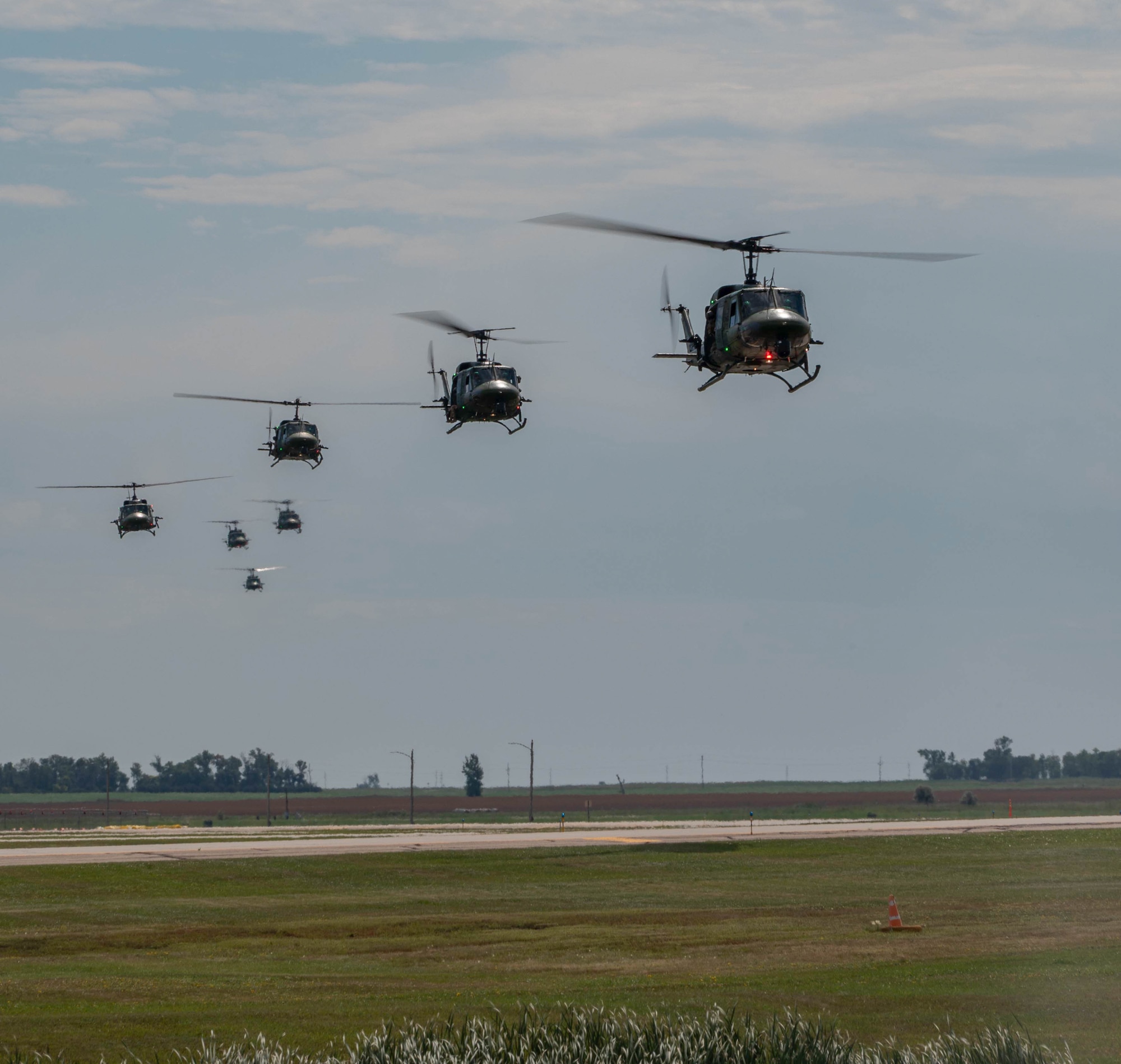 A formation of UH-1N Iroquois helicopters fly over Minot Air Force Base, North Dakota, Aug. 21, 2025. The primary missions of the UH-1N Iroquois include airlifting emergency security forces, providing security and surveillance of off-base nuclear weapons convoys and conducting medical evacuation. (U.S. Air Force photo by Senior Airman Alyssa Bankston)