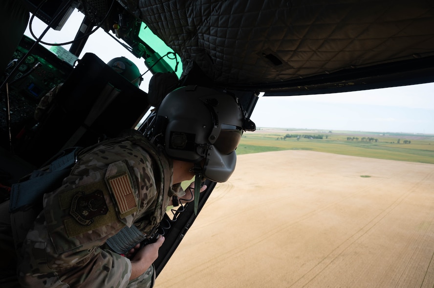U.S. Air Force Staff Sgt. Garrett Hightower, a 54th Helicopter Squadron special missions aviator, looks out of a UH-1N Iroquois helicopter during a turn at Minot Air Force Base, North Dakota, Aug. 21, 2025. The UH-1N has been stationed at Minot AFB since March 20, 1980 and is scheduled to remain until 2029, with the MH-139A expected to arrive in 2027. (U.S. Air Force photo by Airman 1st Class Wesley Davies)
