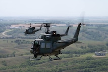 Three UH-1N Iroquois fly in formation during a seven-ship formation flight at Minot Air Force Base, North Dakota, Aug. 21, 2025. The seven helicopters carried Tactical Response Force members for an exercise, employing airpower and air superiority in defense of our nation’s nuclear deterrence arsenal. (U.S. Air Force photo by Airman 1st Class Wesley Davies)