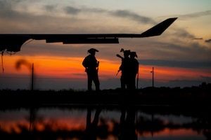 U.S. Air Force explosive ordnance disposal Airmen discuss their plan of action before night vision operations training during Exercise Northern Strike 25-2, Aug. 7, 2025, in Oscoda, Michigan. The team, consisting of members from the active-duty 509th Bomb Wing and the reserve 442nd Fighter Wing, participated in the National Guard Bureau-sponsored exercise, which prepares service members for real-world operations in contested environments. (U.S. Air National Guard photo by Staff Sgt. Whitney Erhart)