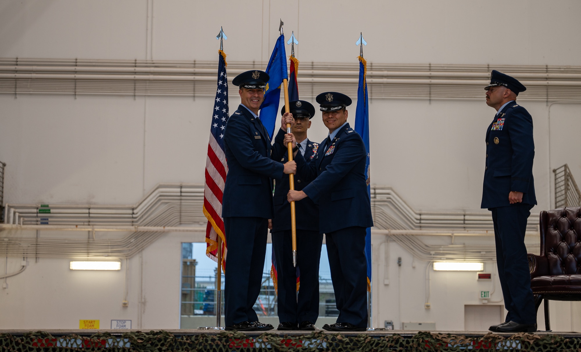 Col. Daniel Mendoza hands the guidon to Col. Dan Cooley during a change of command ceremony.