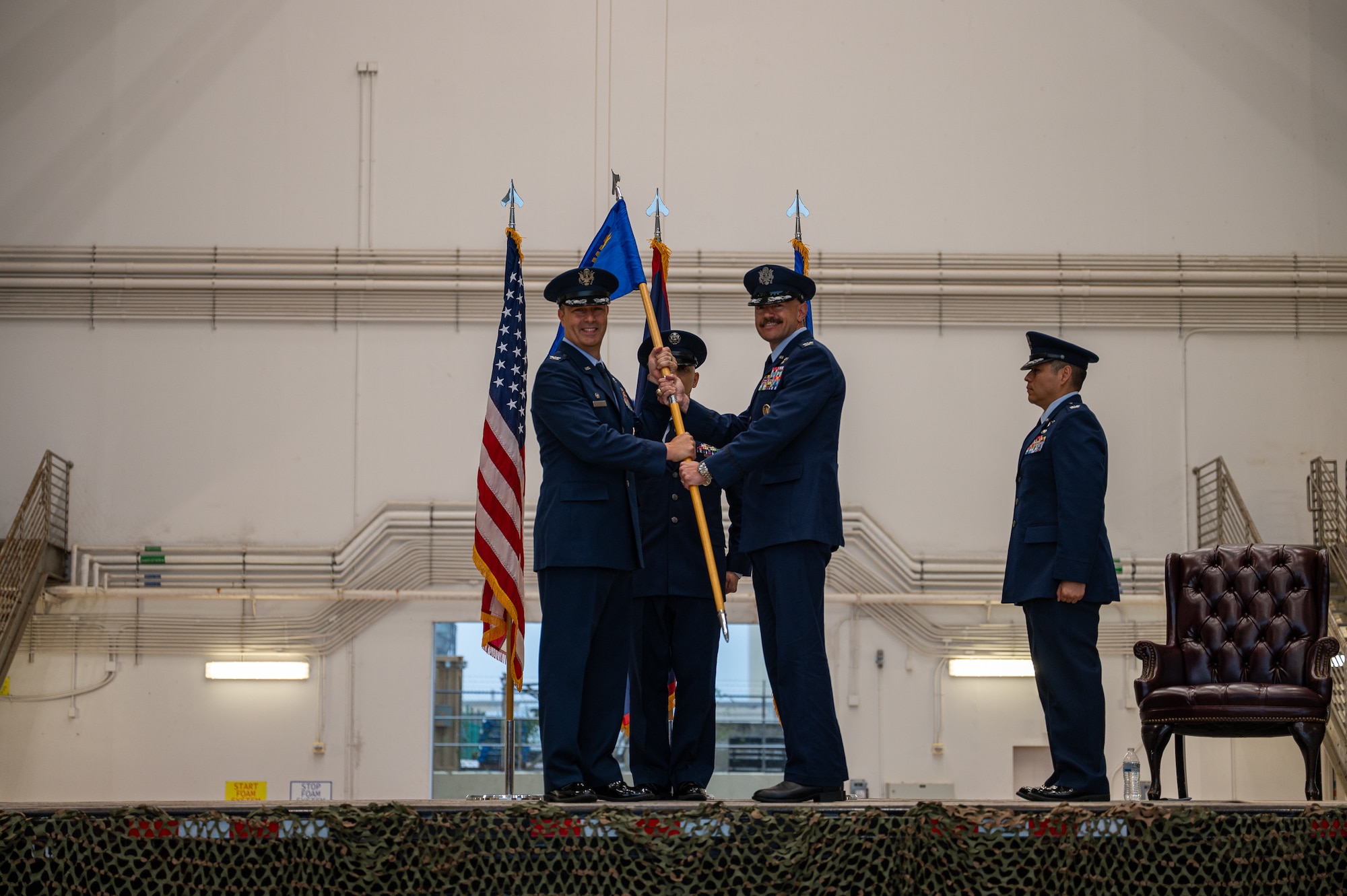 Col. Andrew Miller hands a guidon to Col. Dan Cooley during a change of command ceremony.
