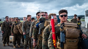 Marines line up in front of aircraft.