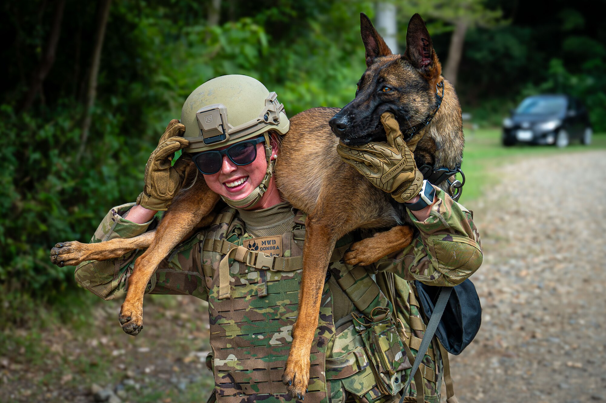 K-9 handler holds up military working dog.