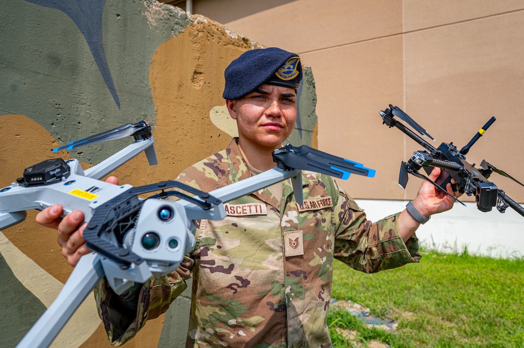 An Airman holds two drones