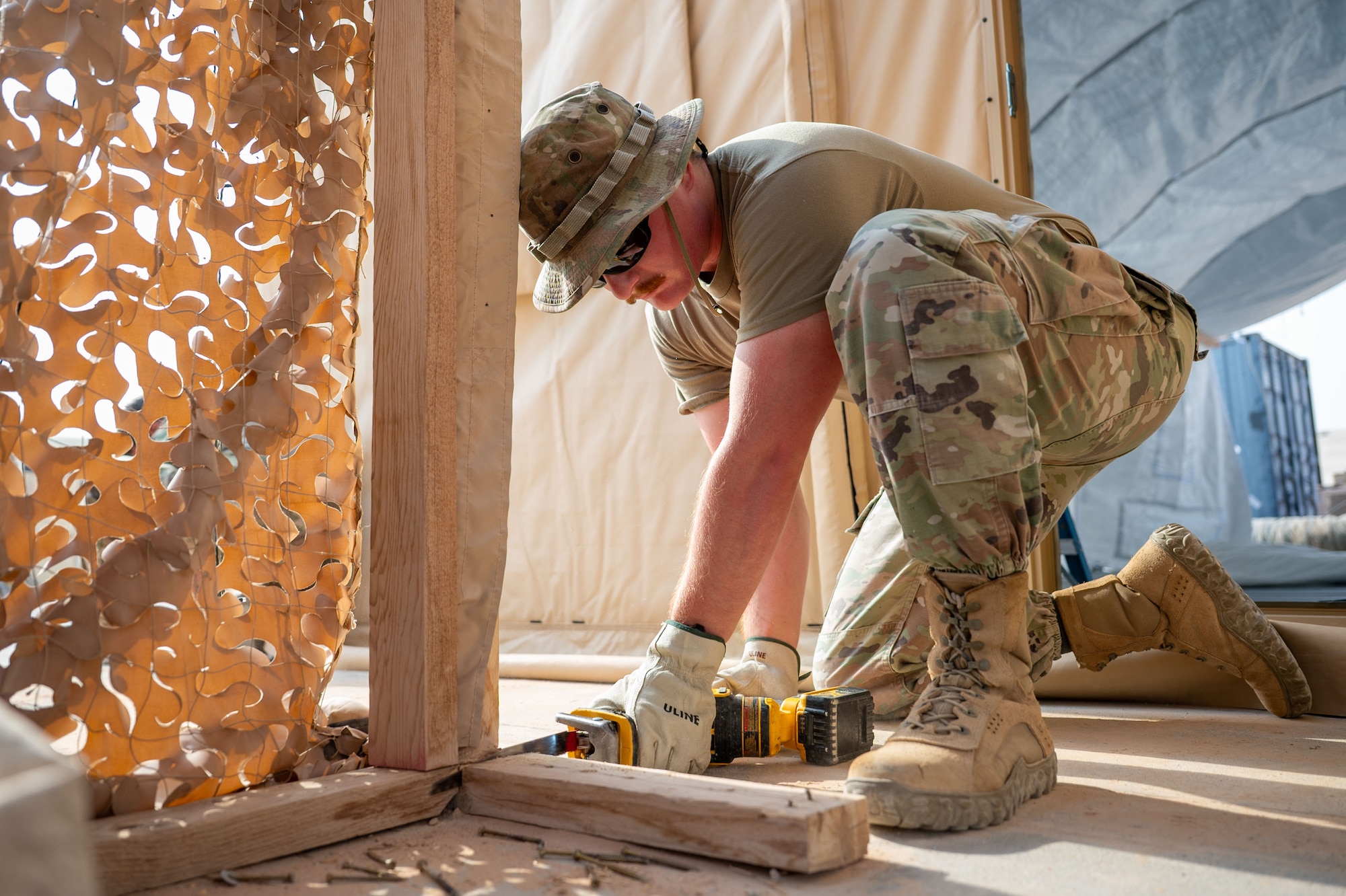 U.S. Air Force Airman 1st Class Nathaniel Cooper, 378th Expeditionary Civil Engineer Squadron structural journeyman, saws a porch frame within the U.S. Central Command area of responsibility, Aug. 18, 2025.