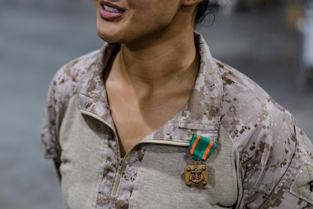 U.S. Marine Corps Lance Cpl. Judith Ann Lazaro, a combat photographer with Headquarters Company, 2d Marine Division, II Marine Expeditionary Force, receives a Navy and Marine Corps Achievement Medal after the completion of Service Level Training Exercise 4-25, at Marine Corps Air-Ground Combat Center, Twentynine Palms, California, Aug. 26, 2025. SLTE 4-25 is designed to be a challenging, realistic training environment that produces combat-ready forces capable of operating as an integrated Marine Air Ground Task Force across all domains of military operations. (U.S. Marine Corps photo by Cpl. Noelia Vazquez)