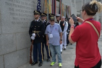 Bob Konrardy, U.S. Army veteran, stands for a photo with the Joint Service Color Guard at the World War II Memorial in Washington, D.C., Aug. 20, 2025. The event honored military veterans from WWII, the Vietnam War and the Korean War during their visit to the National Capital Region. The JSCG consists of service members from all branches of the U.S. military who execute ceremonial honors by presenting and protecting the national flag at official events. The Air Force, Space Force and Navy members of the JSCG are assigned to Joint Base Anacostia-Bolling, Washington, D.C. (U.S. Air Force photo by Airman 1st Class Geneva Nguyen)