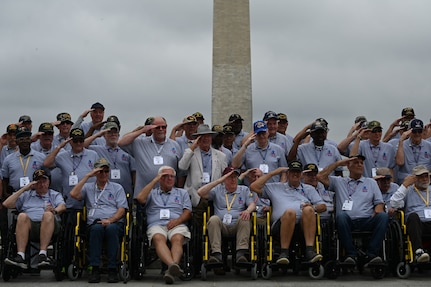 Veterans with Honor Flight Chicago salute the colors during the national anthem presented by the Joint Service Color Guard and The U.S. Air Force Band at the World War II Memorial in Washington, D.C., Aug. 20, 2025. The performance honored military veterans from WWII, the Vietnam War and the Korean War during their visit to the National Capital Region. The Air Force, Space Force and Navy members of the JSCG are assigned to Joint Base Anacostia-Bolling, Washington, D.C. (U.S. Air Force photo by Airman 1st Class Geneva Nguyen)