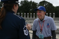 Retired U.S. Air Force Col. Don Masuret, right, Vietnam War pilot, shares pictures of the fighter jet he flew during the war with Master Sgt. Katie Edelman, soprano vocalist with The U.S. Air Force Band, after her performance at the World War II Memorial in Washington, D.C., Aug. 20, 2025. Masuret, radio callsign “Misty 78”, was a pilot on the F-100 “Misty” fighter jet team assigned to fly missions over North Vietnam and the Ho Chi Minh Trail in Laos from 1967 to 1970. Their mission was to identify and mark targets for airstrikes and rescue downed pilots. (U.S. Air Force photo by Airman 1st Class Geneva Nguyen)