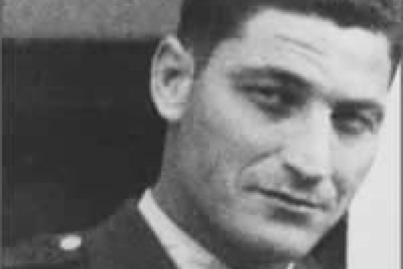 A man in a military dress uniform poses for a photo.