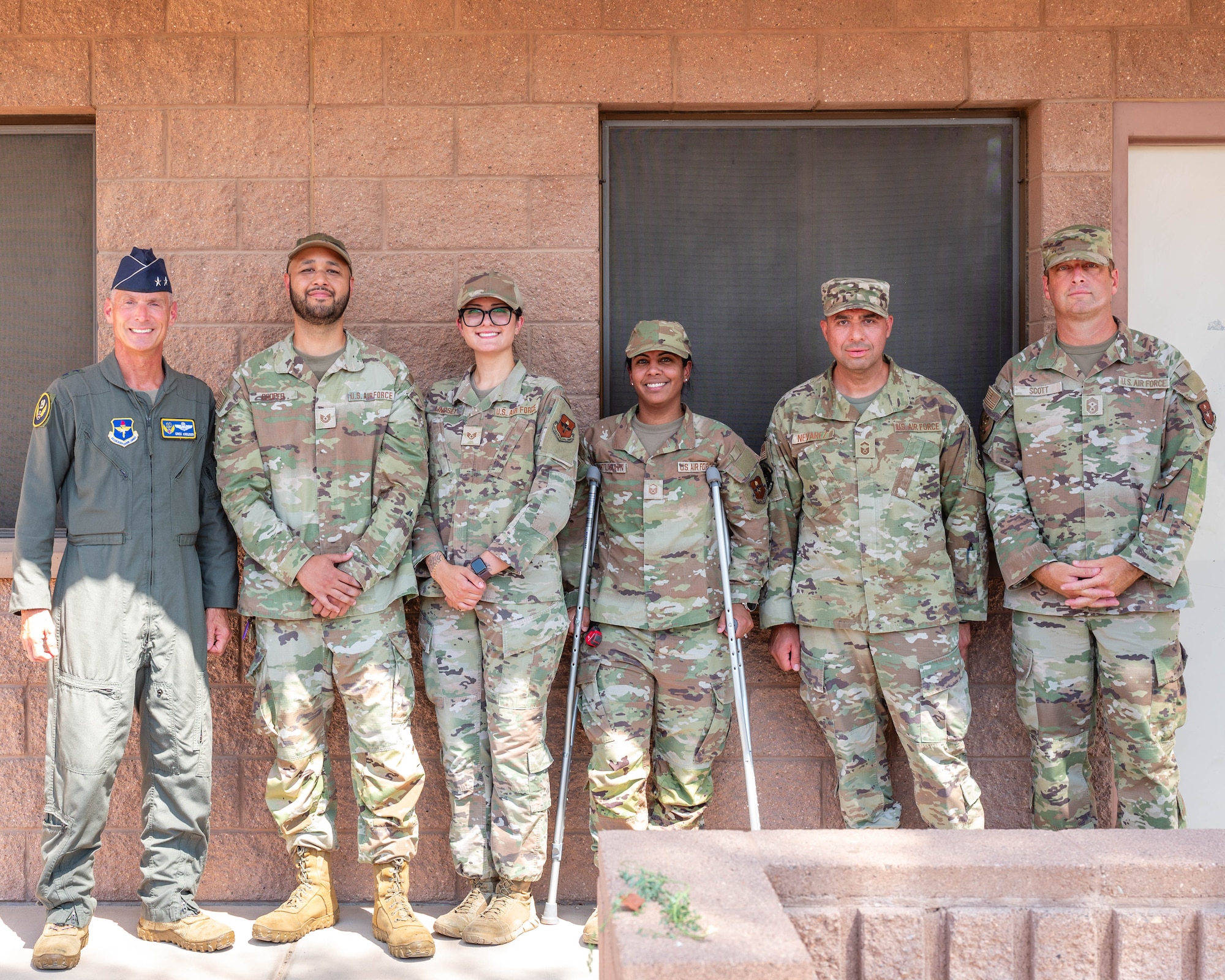 U.S. Air Force Maj. Gen. Gregory Kreuder, 19th Air Force commander, and Chief Master Sgt. Keith Scott, 19th Air Force command chief, take a photo with 56th Civil Engineering Squadron unaccompanied housing airman dorm leaders