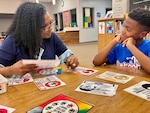 Social worker working with a student in a school library setting.