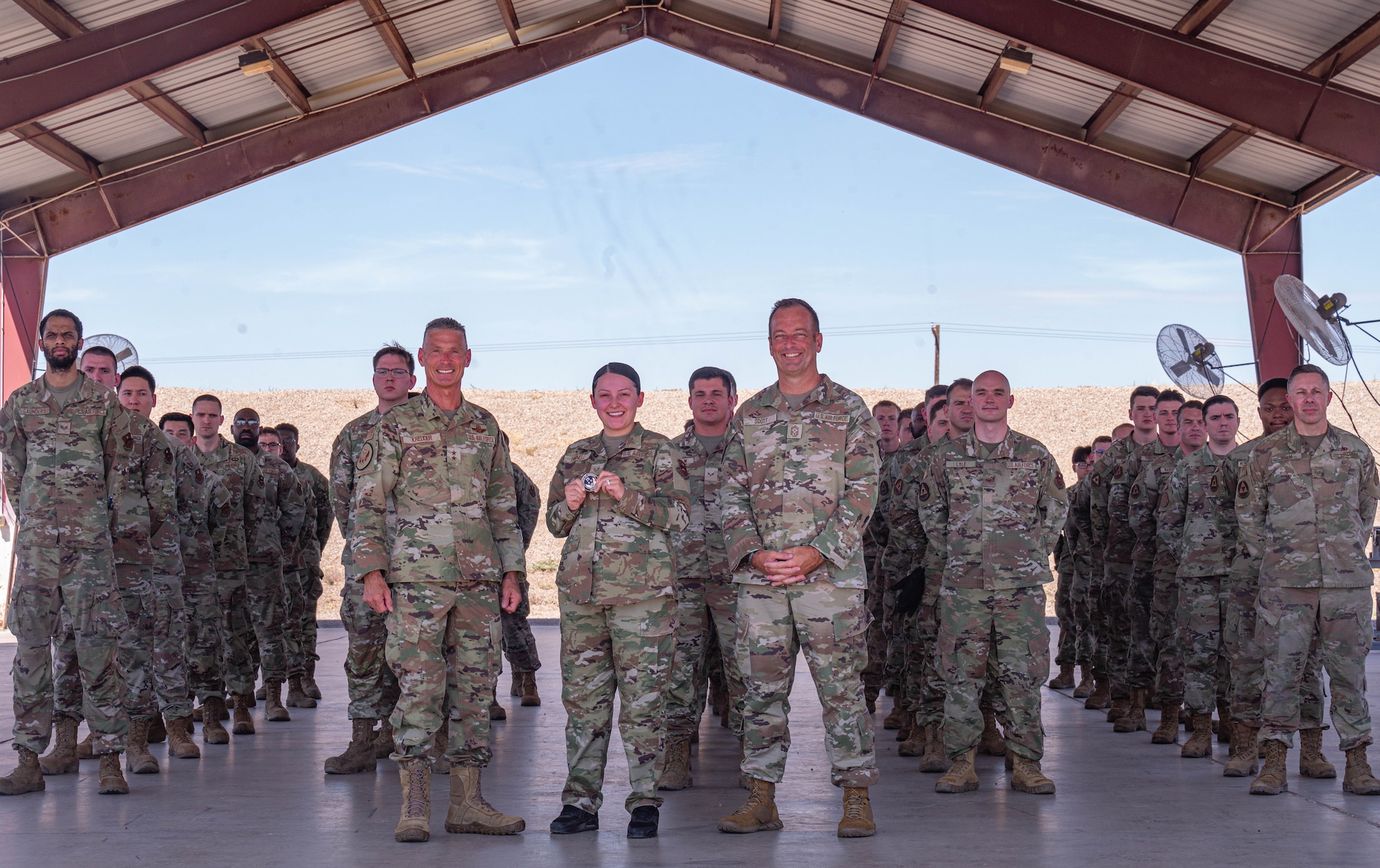 U.S. Air Force Maj. Gen. Gregory Kreuder, Nineteenth Air Force commander, Chief Master Sgt. Keith Scott, Nineteenth Air Force command chief, and Staff Sgt. Tawny Parnell, 56th Equipment Maintenance Squadron training supervisor, take a photo with the 56th EMS