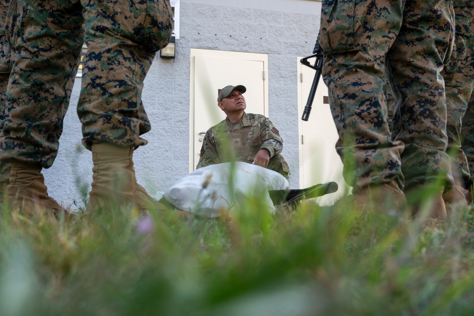 U.S. Air Force Ch, Maj. Benjamin Quintanilla, Air Force Mortuary Affairs Operations senior chaplain, listens to a briefing during an example of burial rites for a Muslism service member on Camp Grayling, Michigan, Aug. 10, 2025. Quintanilla played a key role in religious support team at Northern Strike 25-2. (U.S. Air Force photo by Senior Airman Madeline Baisey)