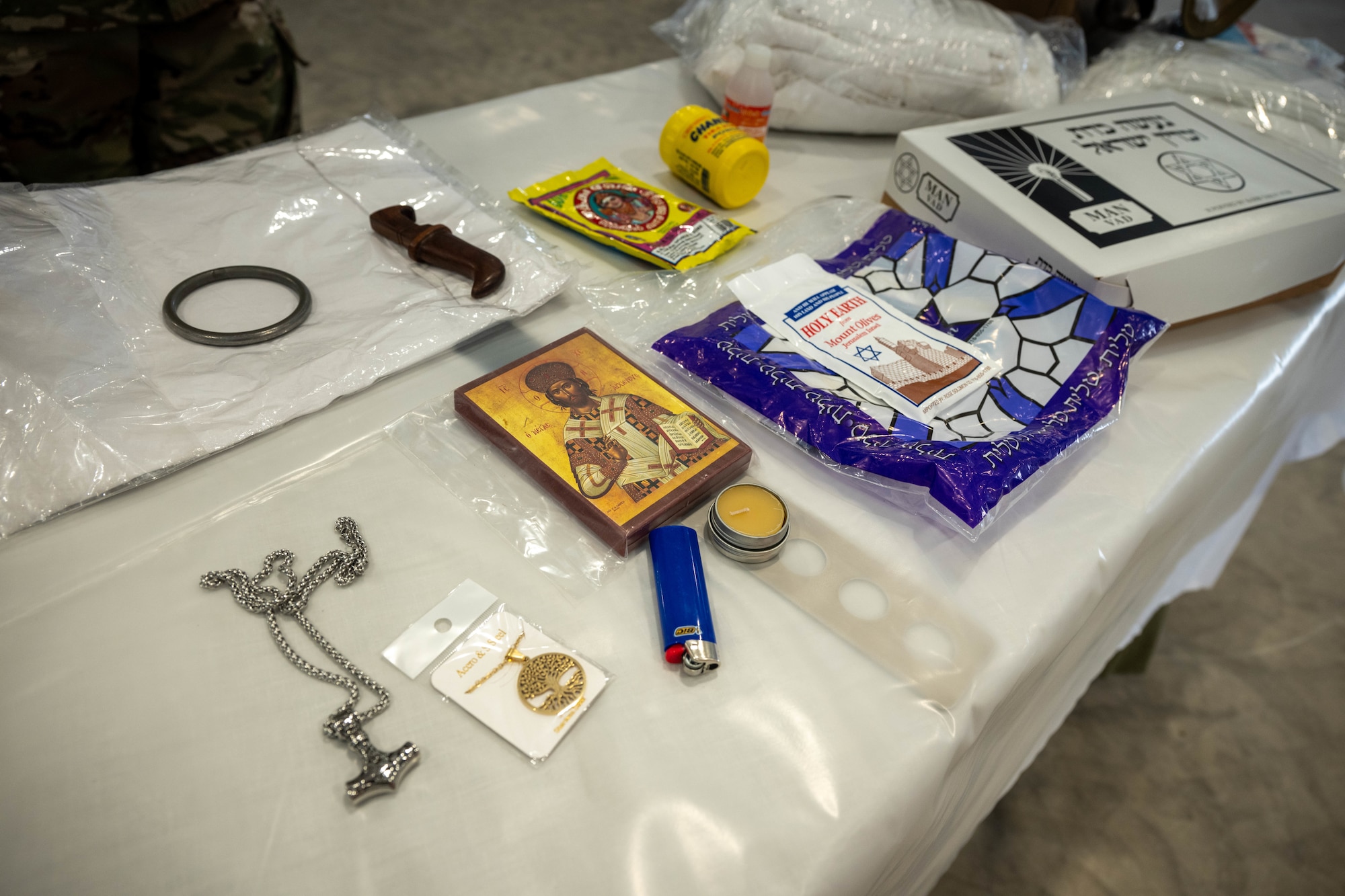 A prototype display of a "Death for the Care and Dying kit" lies on a table in the warehouse for the expeditionary mortuary at Grayling Army Airfield, Aug. 11, 2025. The kit contains religious burial items for faith groups that require care after death. (U.S. Air Force photo by Senior Airman Madeline Baisey)