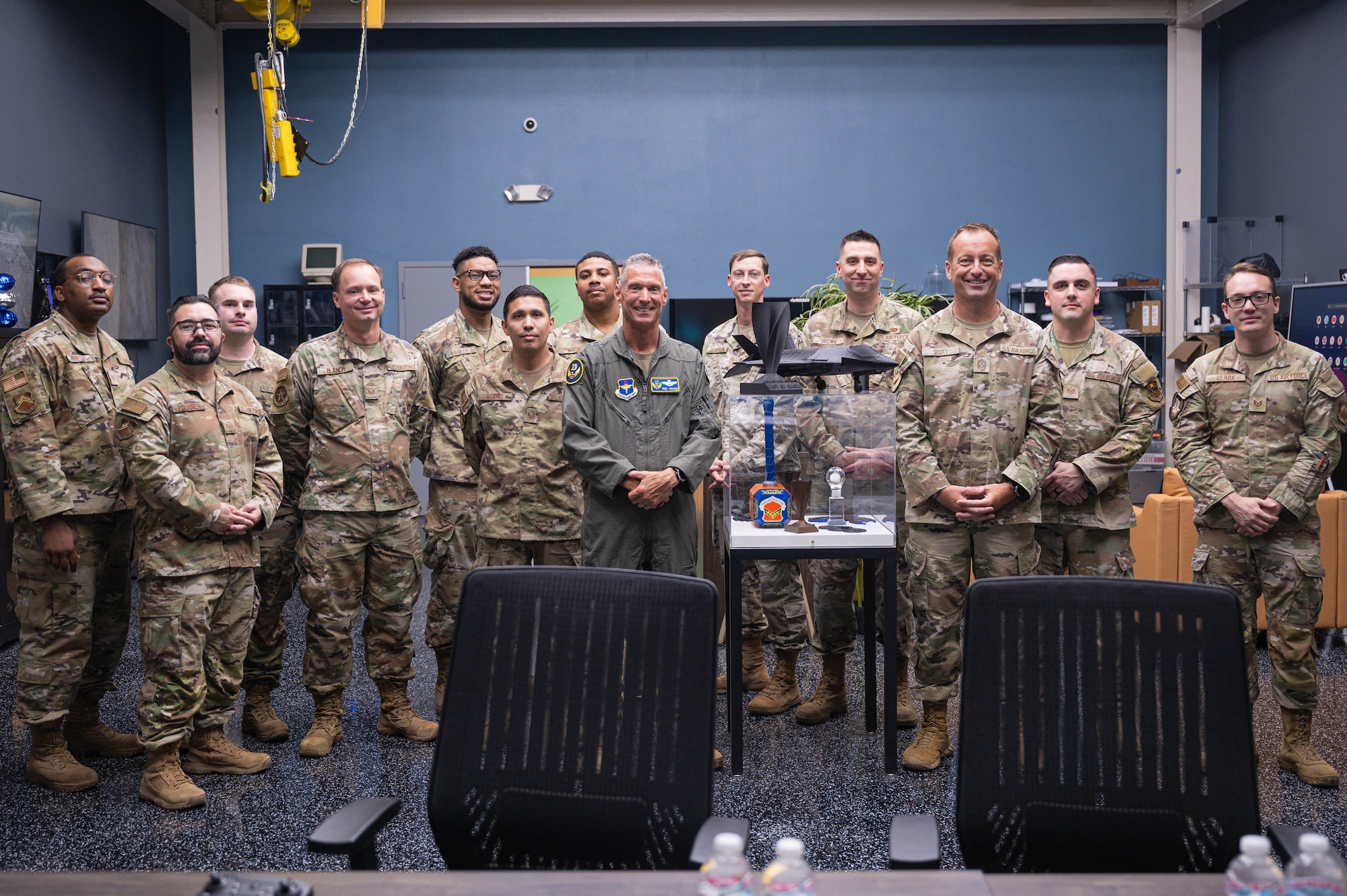U.S. Air Force Maj. Gen. Gregory Kreuder (center left), 19th Air Force commander, Chief Master Sgt. Keith Scott (center right), 19th Air Force command chief, take a photo with the Fighter Country Innovation team